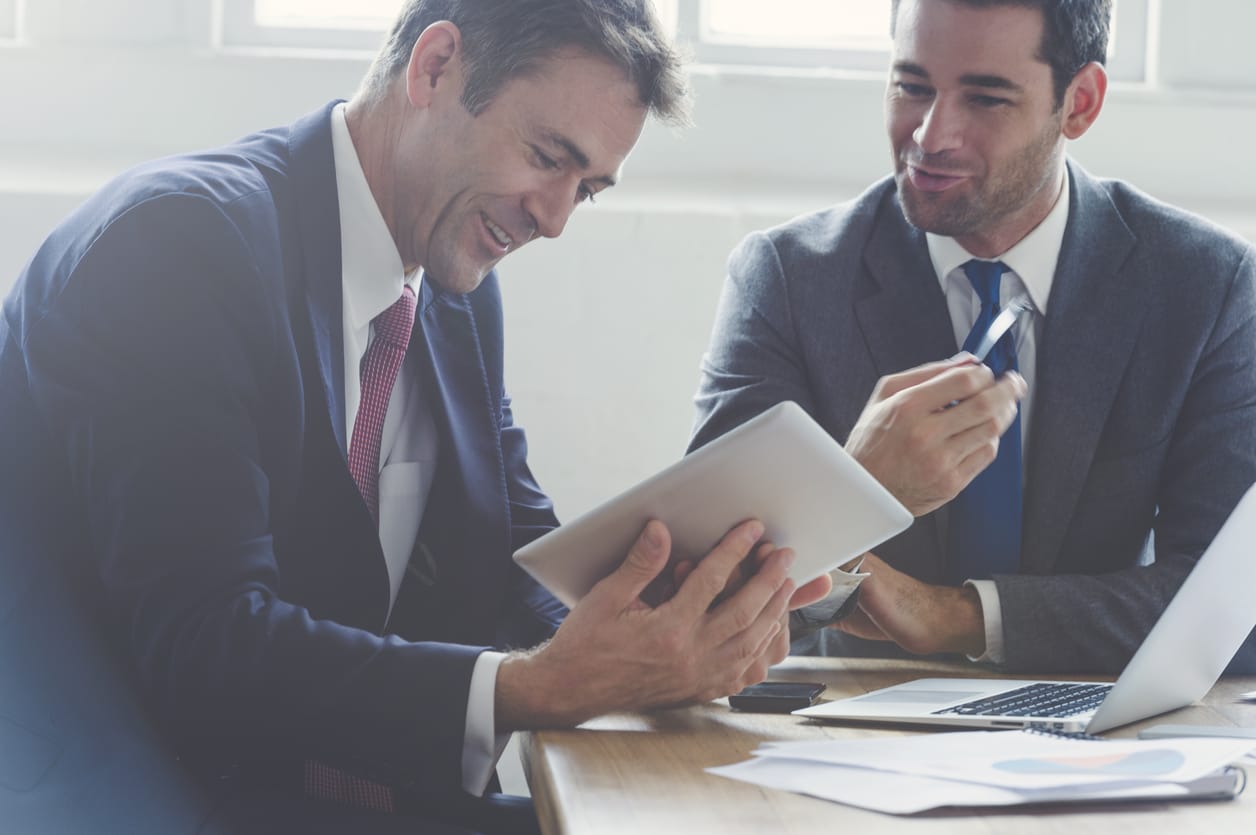 Smiling businessmen using project management software on tablet
