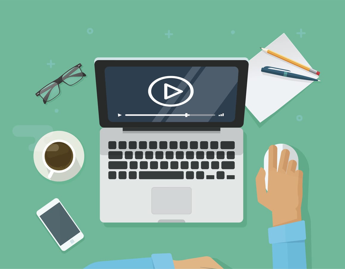 workplace with person watching a video on laptop