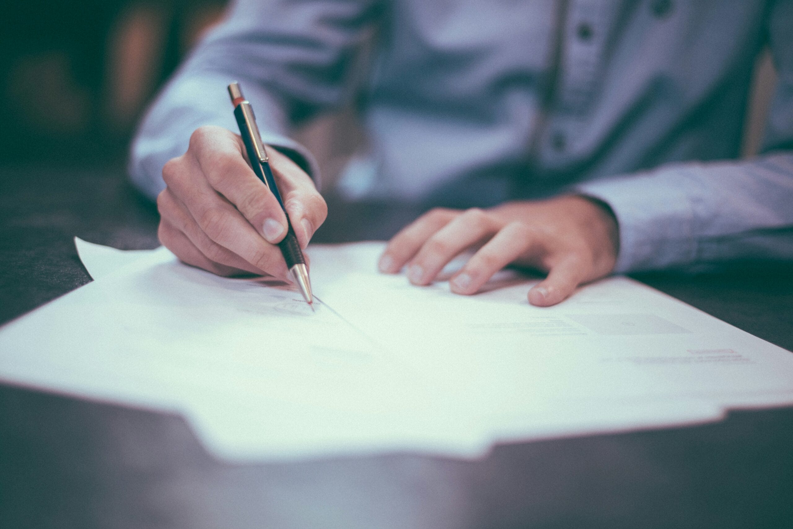 Person reviewing budget with a pen.