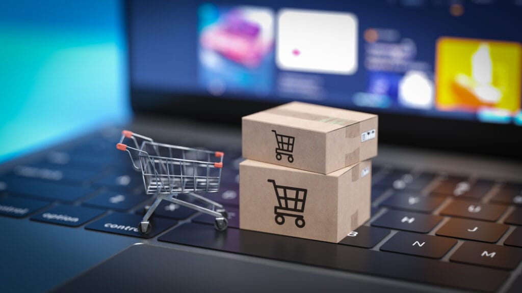 Shopping cart and boxes on laptop keyboard.