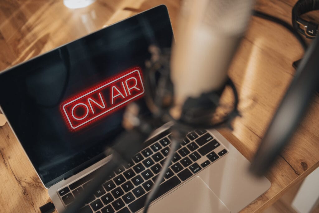 Laptop with the words On Air on screen on a table.