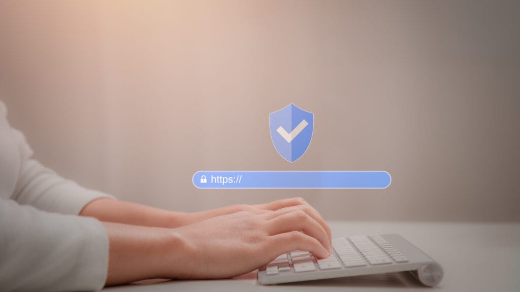 Hands of a woman working on a wireless keyboard with an overlay of security icon and address bar for enterprise websites