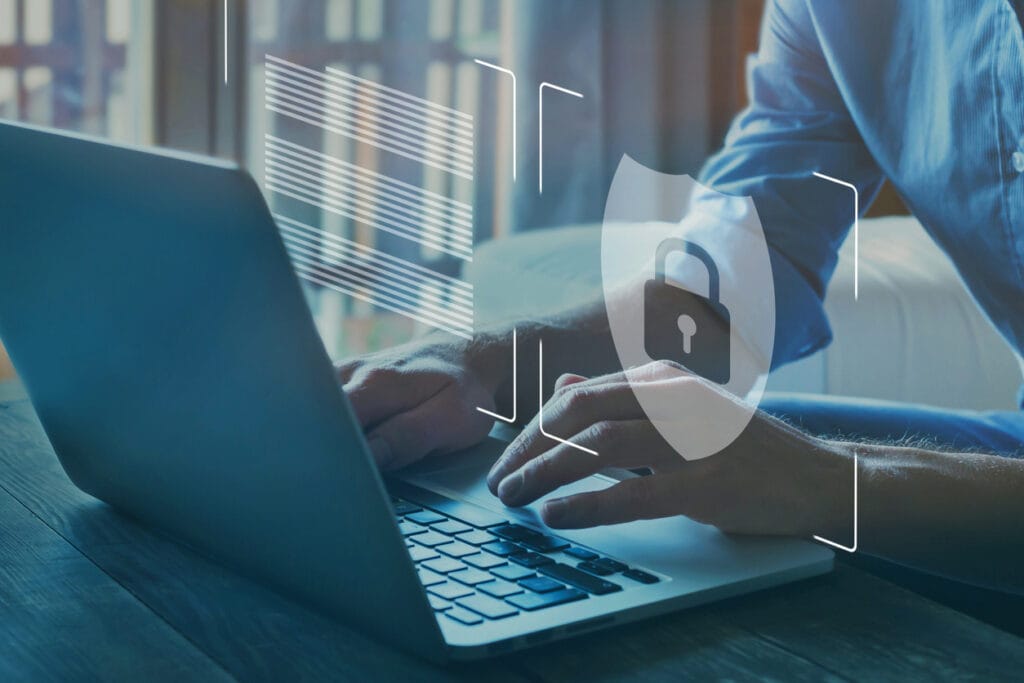 Cropped shot of a man updating media platform on a laptop with cybersecurity icon overlay